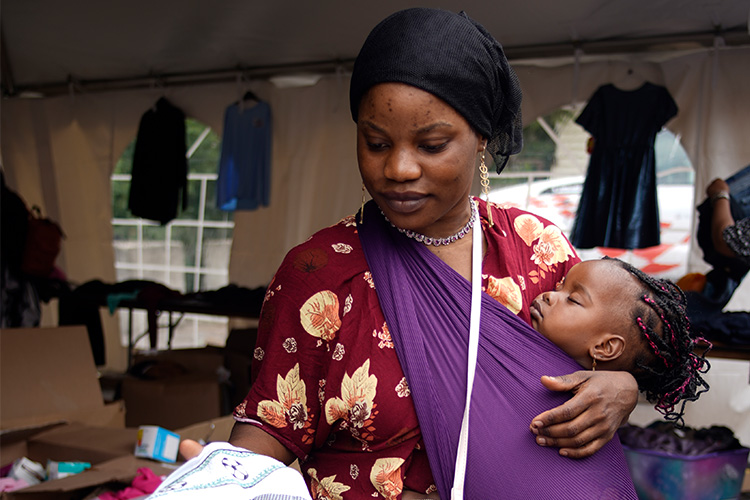 Family receives donated clothing and household supplies at a Mary Nelson community event supported by Good360, highlighting the importance of household goods donations for nonprofits.