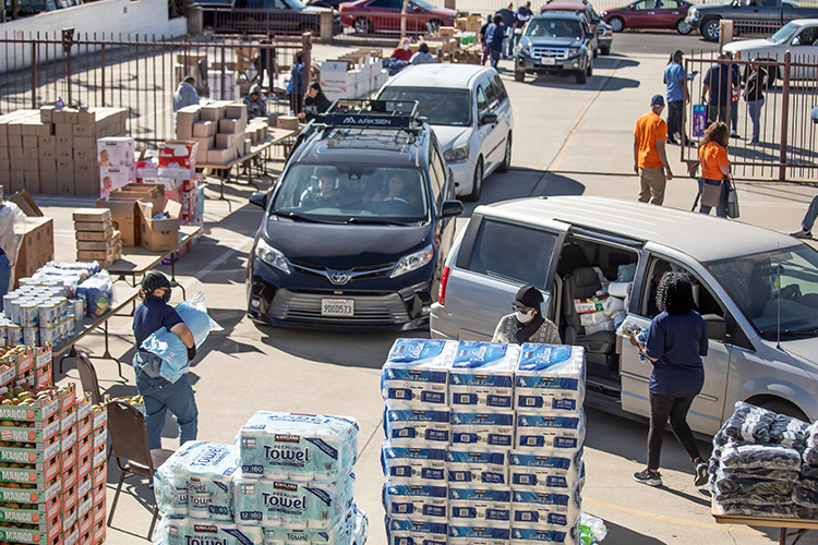 Volunteers with World Vision distribute essential goods during a drive-through disaster recovery donation event after the LA wildfires.