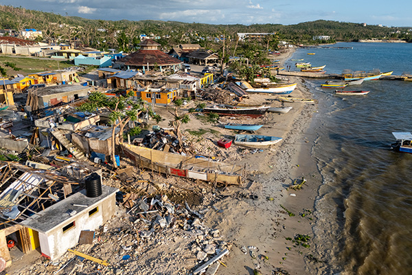 Aerial view of a coastal community in Jamaica showing widespread damage months after Hurricane Melissa.