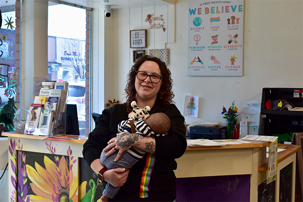 Jessie Avalos, founder of Sweet Potato's Closet, holds a baby at the nonprofit's front desk in Hermiston, Oregon