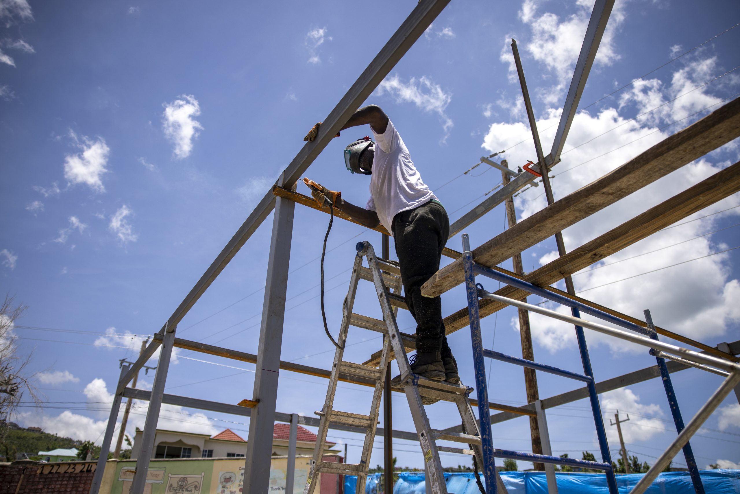 A construction worker in White House, Jamaica, assembles the frame for a new building with donated materials sourced by Good360.