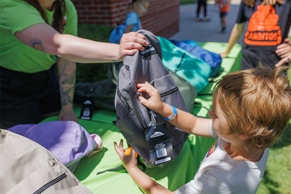 A child receives a backpack filled with school supplies and activities at Good360 and Project:Camp's Built to Play distribution event in London, Kentucky